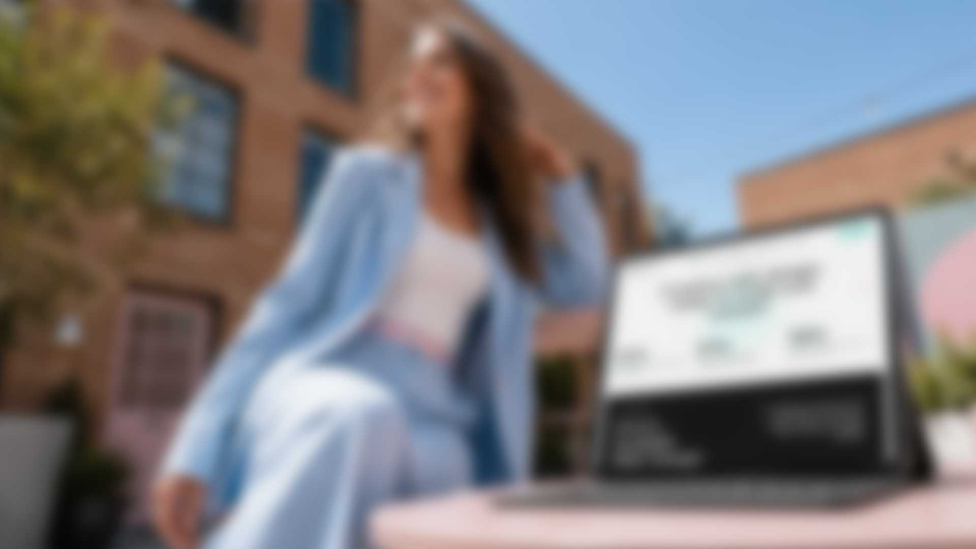 Woman using a laptop outdoors, representing digital branding and web design services.