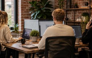 Team of designers working on computers in a modern office.